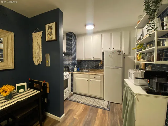 a kitchen with a refrigerator and a stove top oven