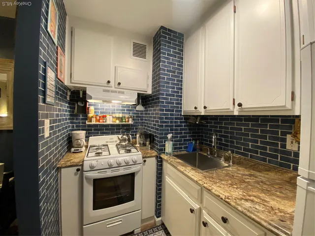a kitchen with a sink stove and cabinets