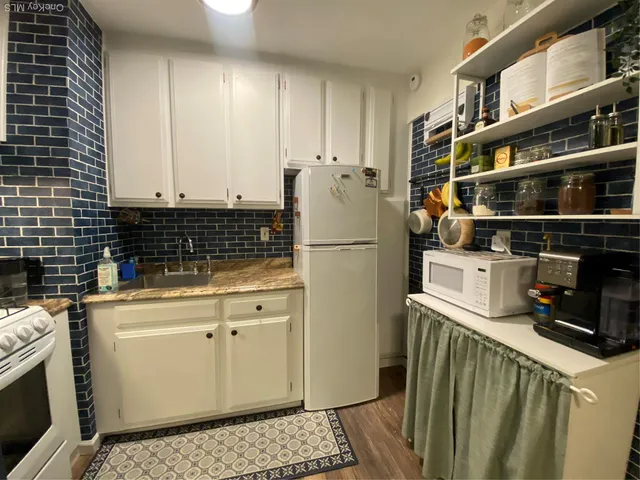 a kitchen with a refrigerator a stove and cabinets