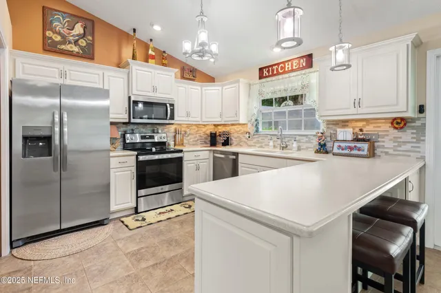 a kitchen with stainless steel appliances a refrigerator sink and microwave