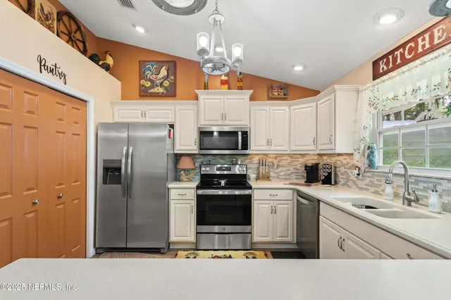 a kitchen with stainless steel appliances a stove refrigerator sink and microwave