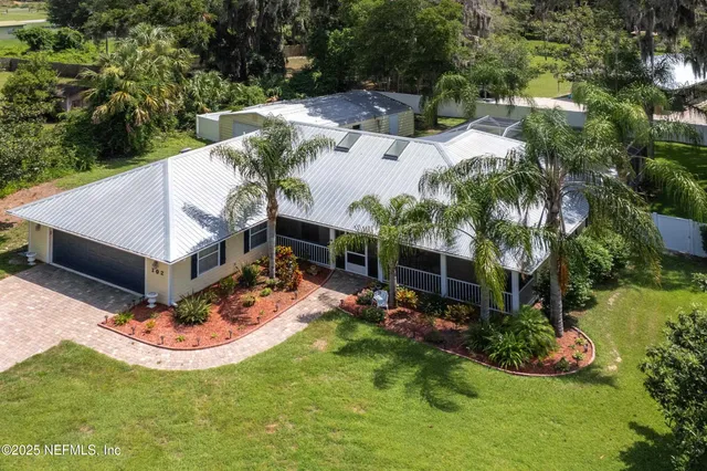an aerial view of a house with a yard and lake view