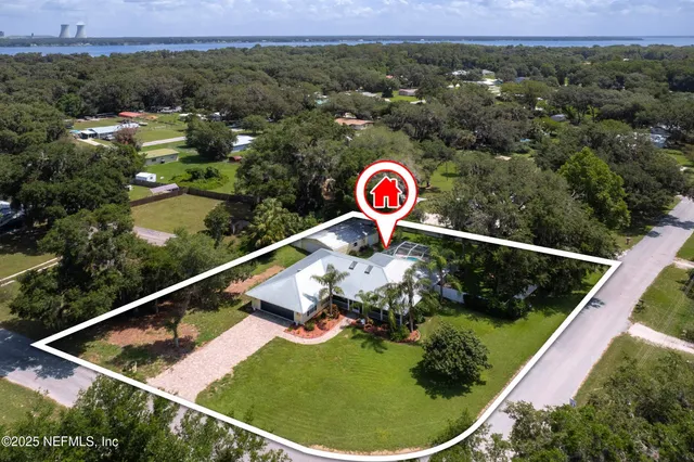 an aerial view of a house with a yard and lake view