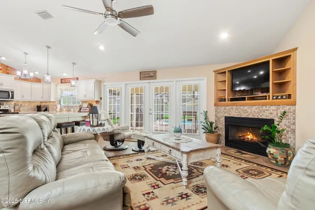 a living room with furniture a flat screen tv and a fireplace