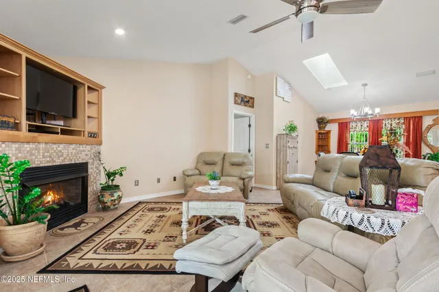 a living room with furniture a flat screen tv and a fireplace