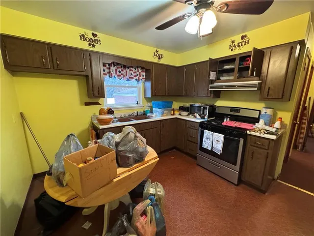 a kitchen with stainless steel appliances kitchen island granite countertop a sink and cabinets