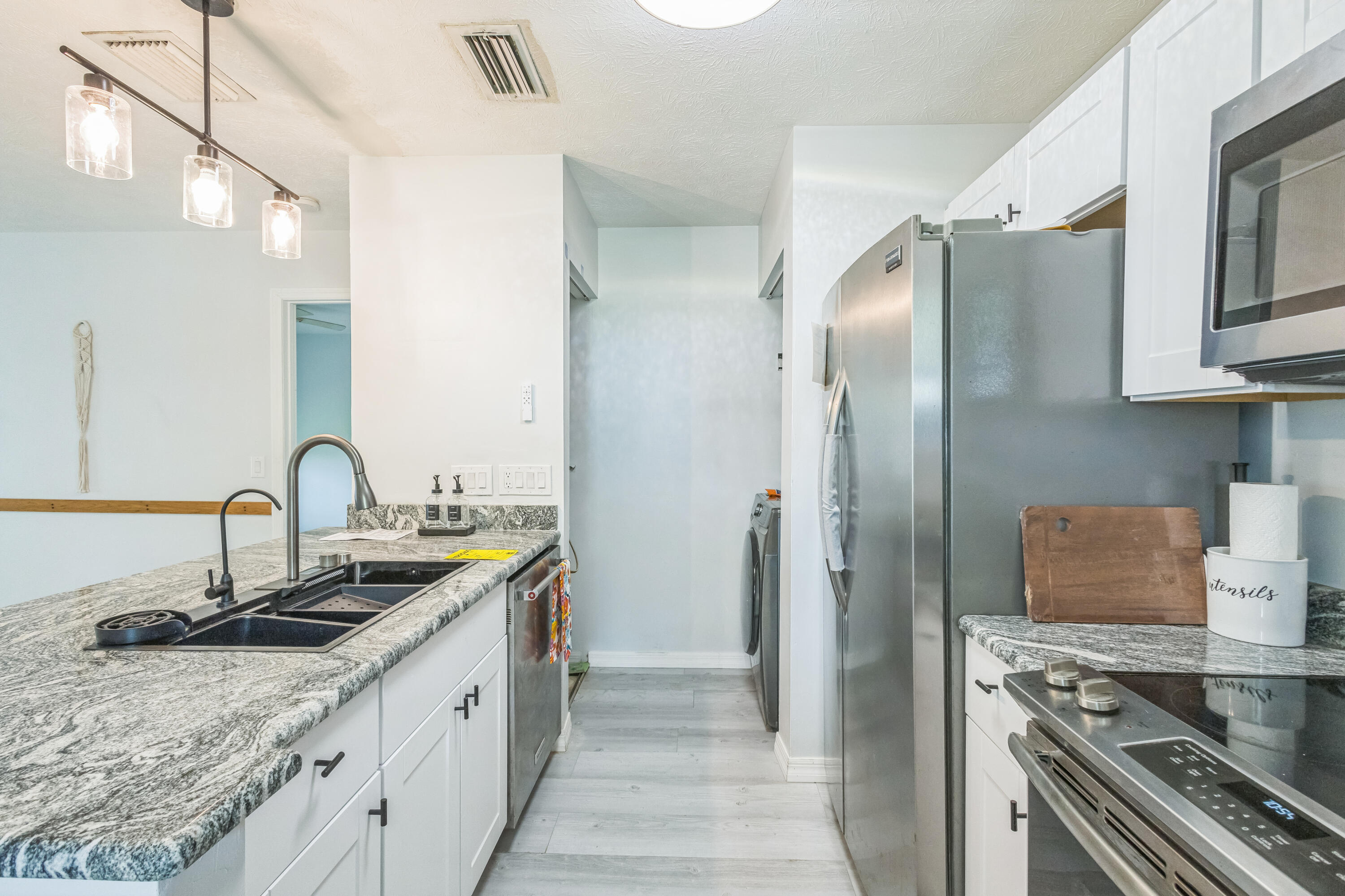 a kitchen with stainless steel appliances granite countertop a sink stove and refrigerator