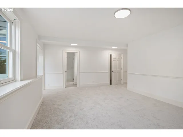 a view of an empty room with window and cabinet