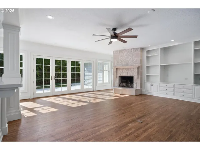 a view of an empty room with a fireplace and a window