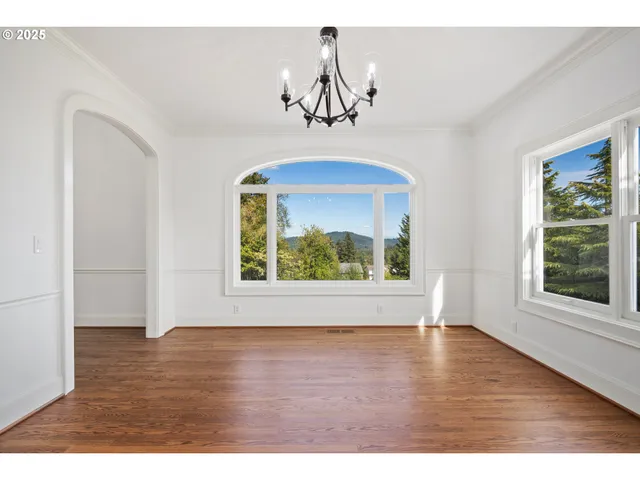 a view of wooden floor chandelier and windows in a room