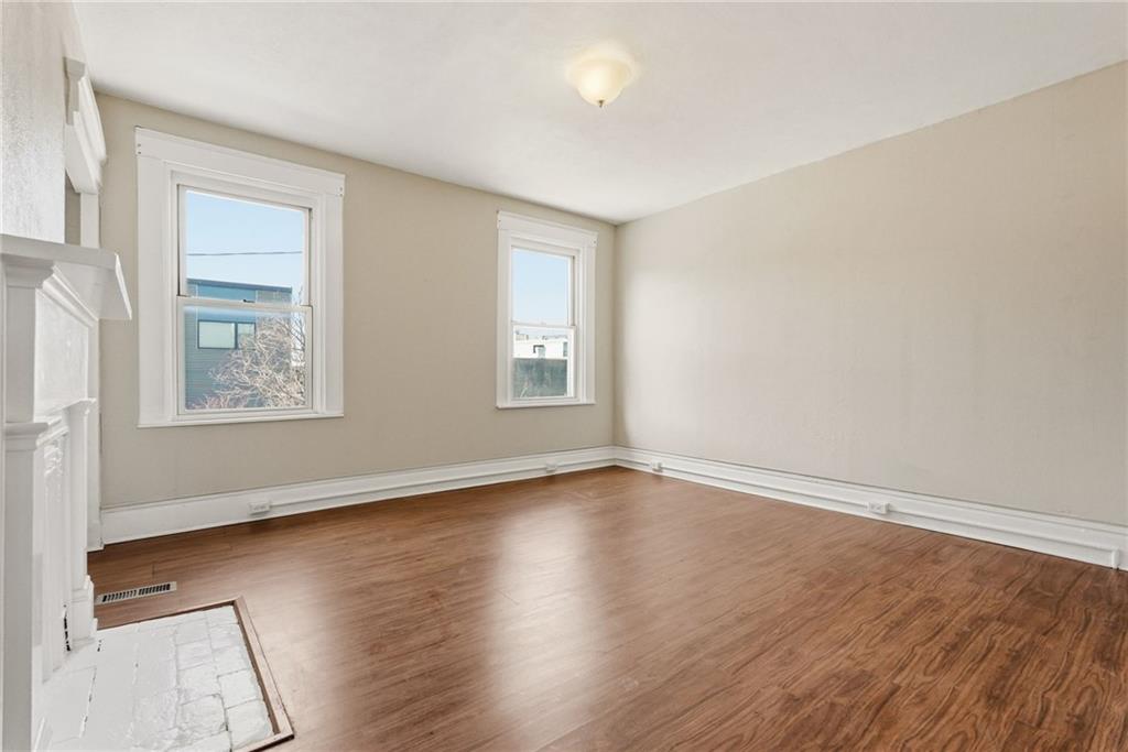 218 39th Street Pittsburgh, PA 15201 - Photo 16 of 24 an empty room with wooden floor and windows