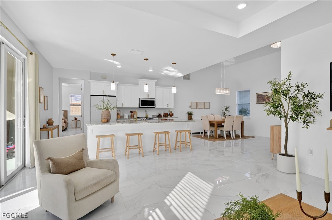 1207 Sheldon Avenue Lehigh Acres, FL 33972 - Photo 15 of 48 a living room with furniture potted plant and kitchen view