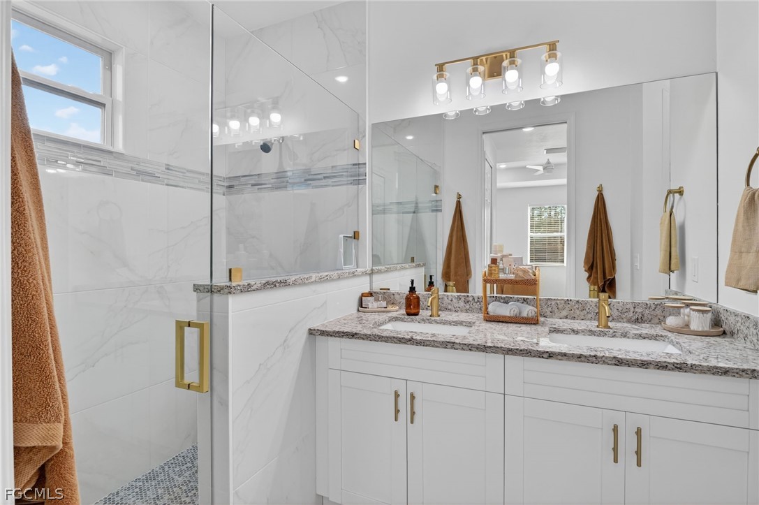 1207 Sheldon Avenue Lehigh Acres, FL 33972 - Photo 18 of 48 a bathroom with a double vanity sink and a mirror