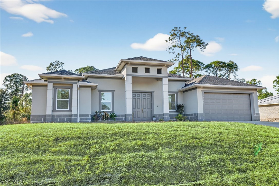 1207 Sheldon Avenue Lehigh Acres, FL 33972 - Photo 2 of 48 a front view of house with yard and garage