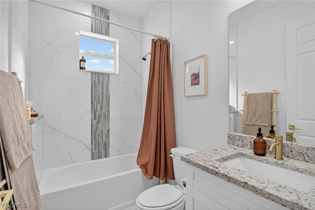 1207 Sheldon Avenue Lehigh Acres, FL 33972 - Photo 22 of 48 a bathroom with a granite countertop sink toilet and shower