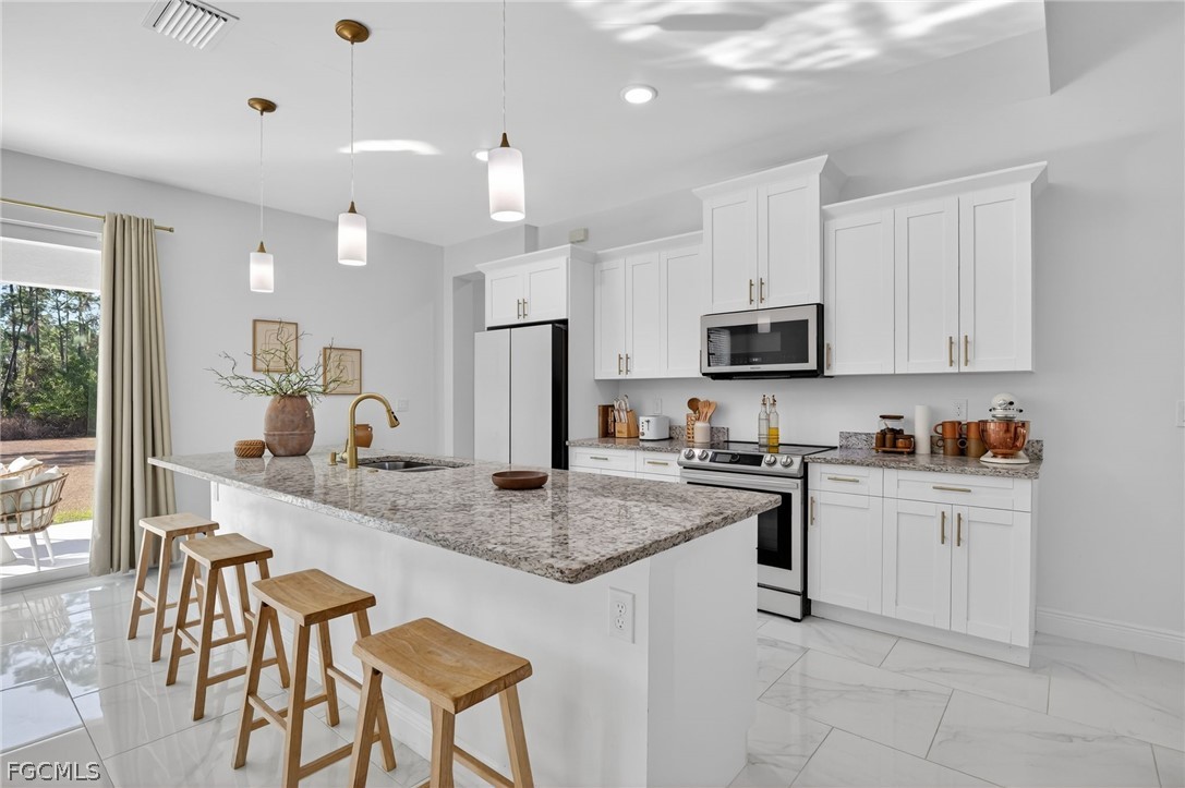 1207 Sheldon Avenue Lehigh Acres, FL 33972 - Photo 8 of 48 a kitchen with stainless steel appliances granite countertop a stove top oven a sink dishwasher a dining table and chairs with wooden floor