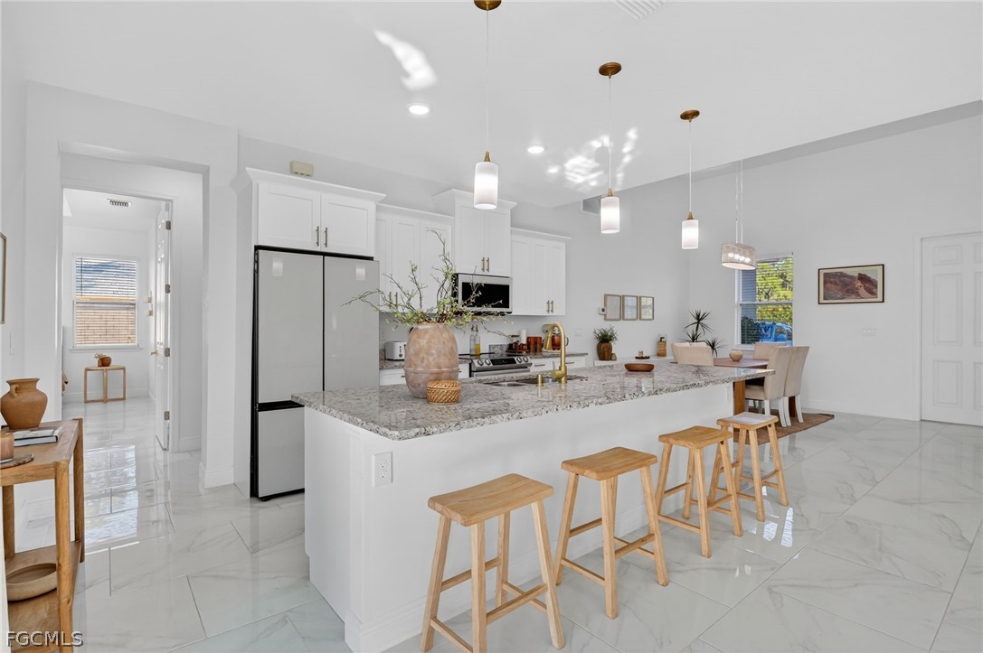 1207 Sheldon Avenue Lehigh Acres, FL 33972 - Photo 10 of 48 a large kitchen with a table and chairs