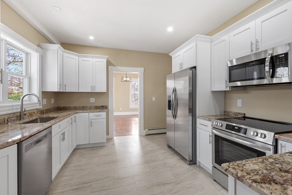 73 Cherry Street Gardner, MA 01440 - Photo 6 of 41 a kitchen with stainless steel appliances granite countertop a stove a refrigerator and a microwave