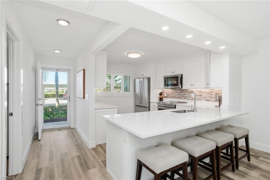 305 Goodlette-Frank Road, Unit C205 Naples, FL 34102 - Photo 5 of 26 Breakfast Bar offers additional seating with extra power supplies underneath to accomodate laptops