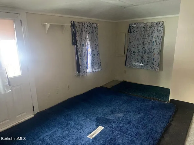 a view of a small space with wooden floor and a window