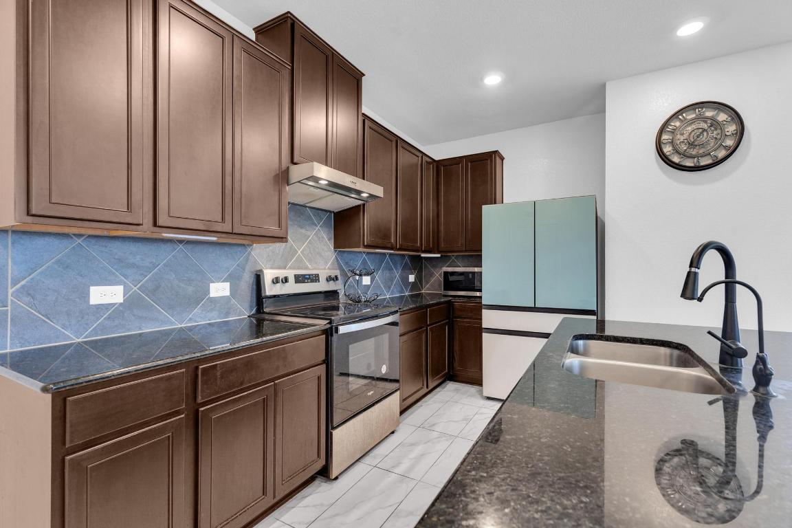 14516 Isidors Eagle Way Elgin, TX 78621 - Photo 5 of 21 a kitchen with granite countertop stainless steel appliances and a sink