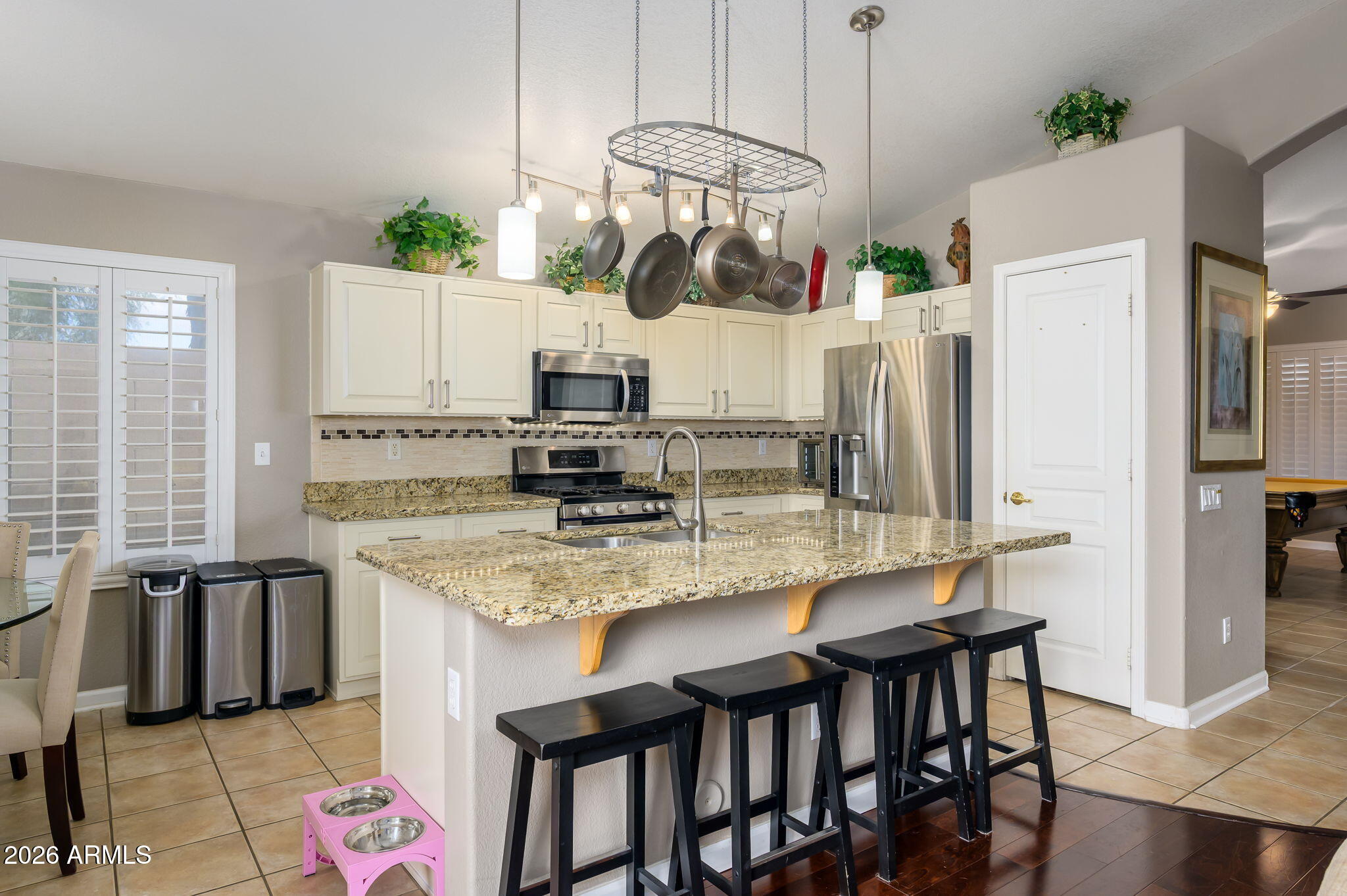 3136 East Roveen Avenue Phoenix, AZ 85032 - Photo 10 of 38 a kitchen with stainless steel appliances granite countertop a stove a refrigerator and a dining table with white cabinets