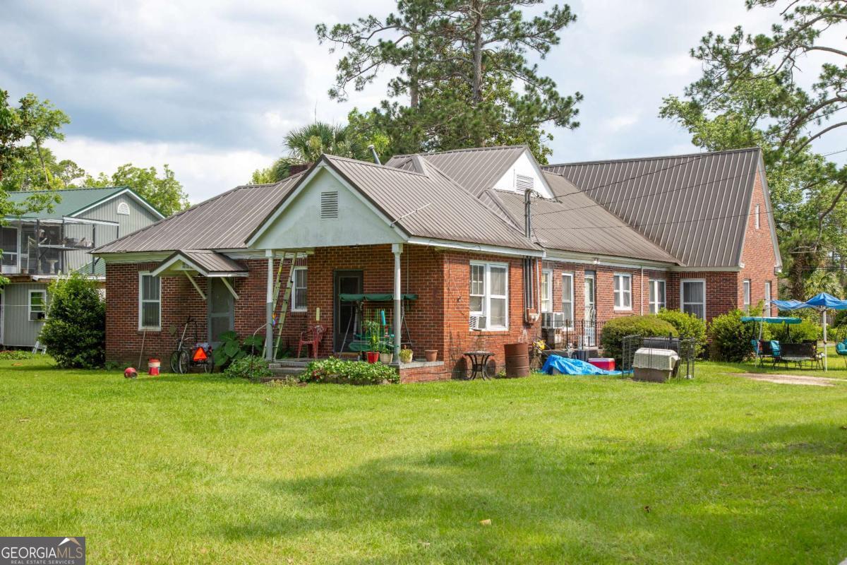 199 Anthony Street Baxley, GA 31513 - Photo 2 of 4 a front view of a house with a yard garden and trees
