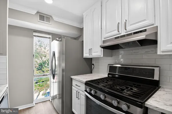 a kitchen with stainless steel appliances granite countertop a stove and a refrigerator