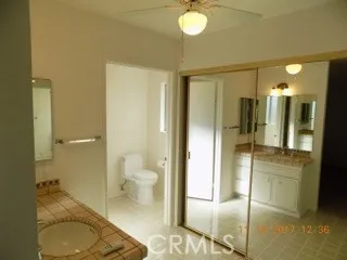 a bathroom with a granite countertop sink mirror vanity and toilet