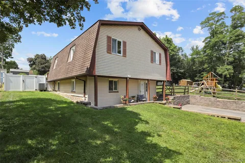 a front view of a house with a yard and trees