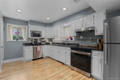 a kitchen with granite countertop a refrigerator stove top oven and sink