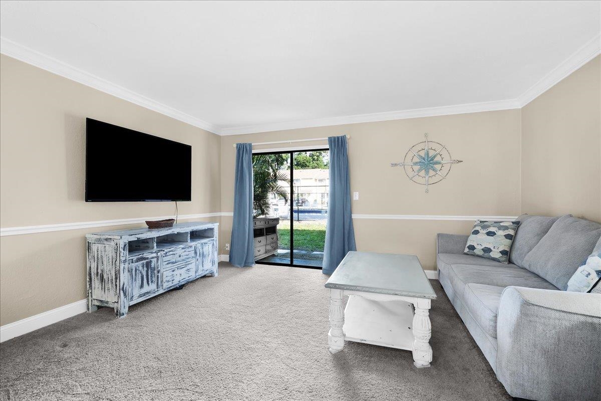 480 Reed Canal Road, Unit 16 Daytona Beach, FL 32119 - Photo 11 of 31 a living room with furniture and a flat screen tv