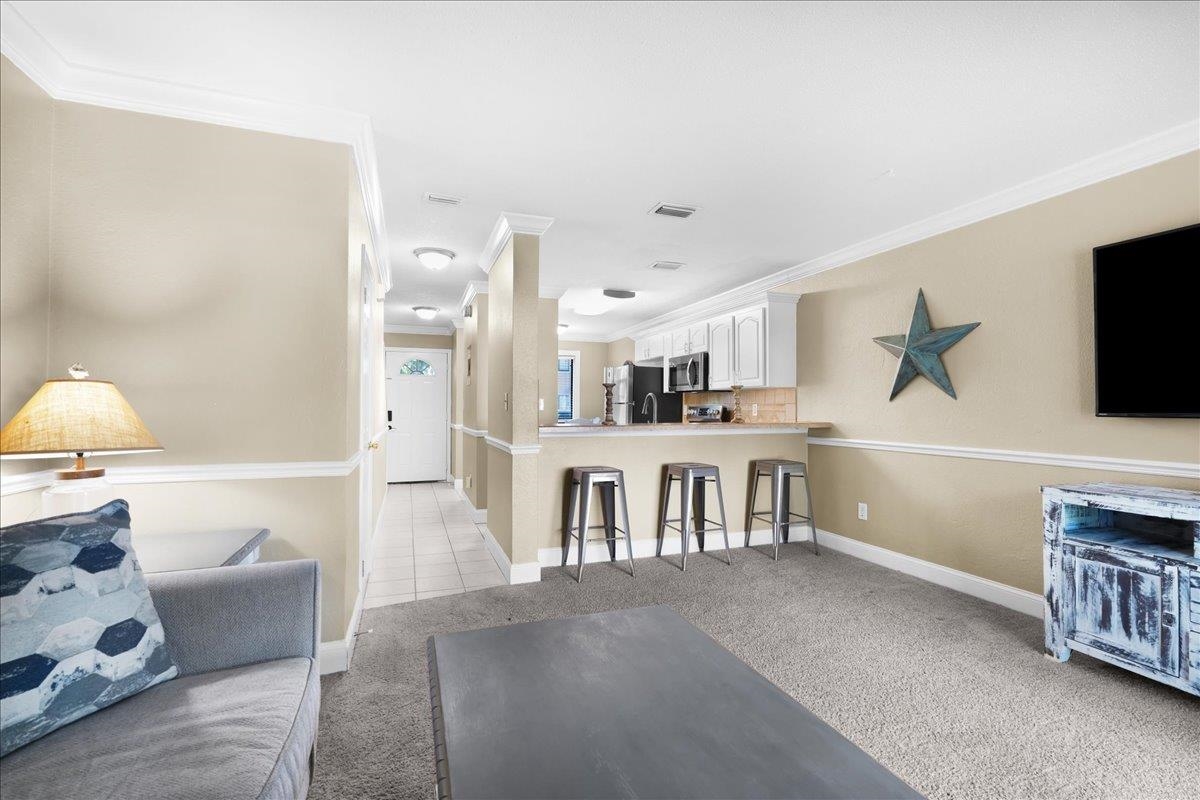 480 Reed Canal Road, Unit 16 Daytona Beach, FL 32119 - Photo 12 of 31 a living room with fireplace furniture and a flat screen tv