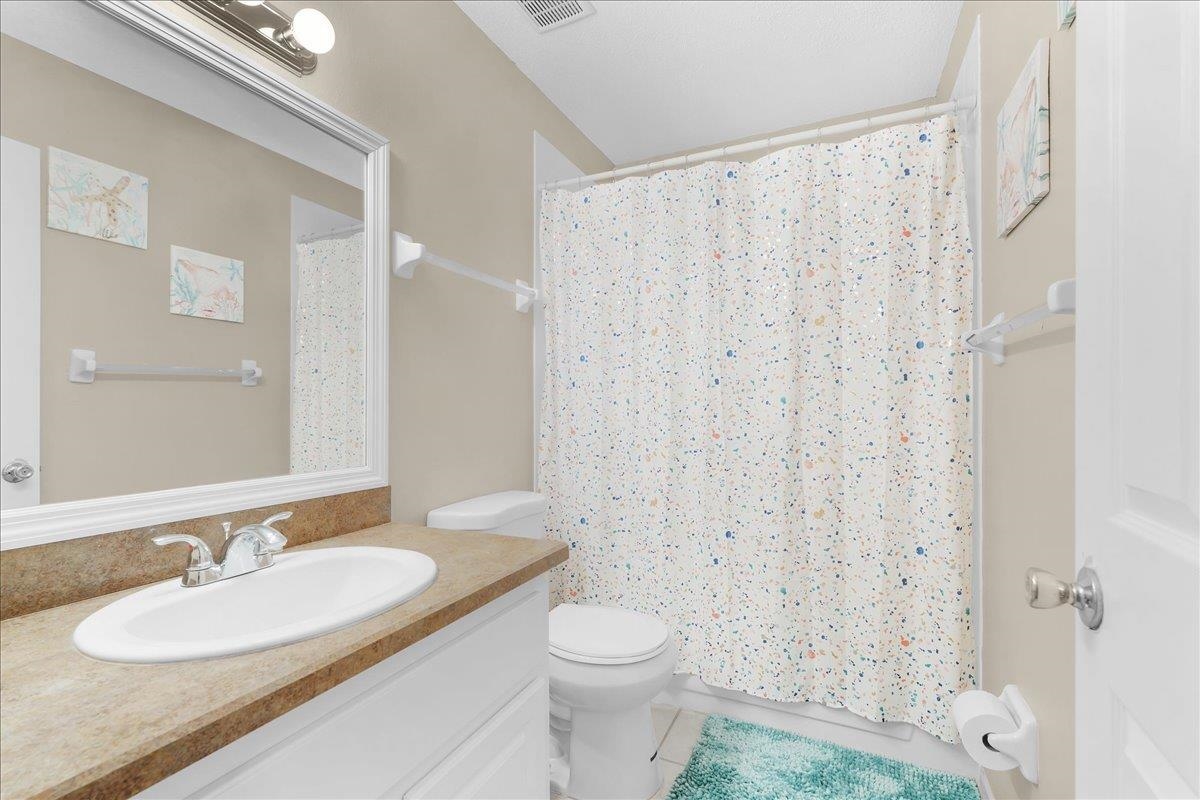 480 Reed Canal Road, Unit 16 Daytona Beach, FL 32119 - Photo 21 of 31 a bathroom with a granite countertop sink toilet and shower