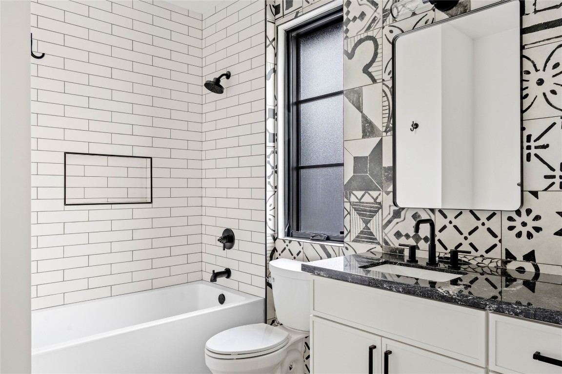 1803 Palo Duro Road Austin, TX 78757 - Photo 25 of 34 Bathroom with vanity, shower / tub combination, and decorative backsplash