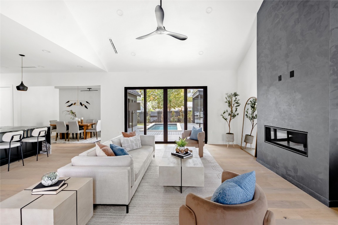 1803 Palo Duro Road Austin, TX 78757 - Photo 8 of 34 Living area featuring light wood-style flooring, lofted ceiling, a large fireplace, and ceiling fan