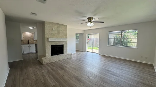a view of an empty room with a fireplace and a window