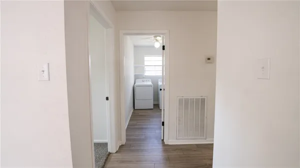 a view of a hallway with wooden floor
