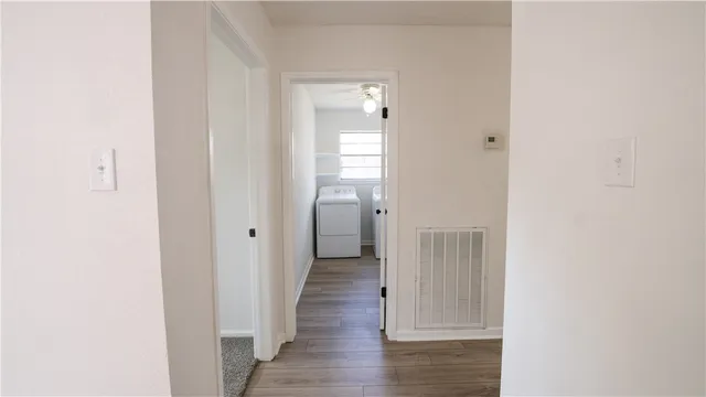 a view of a hallway with wooden floor