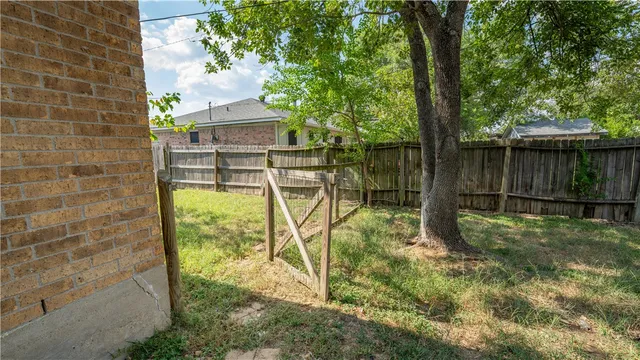 a backyard of a house with lots of green space and fountain