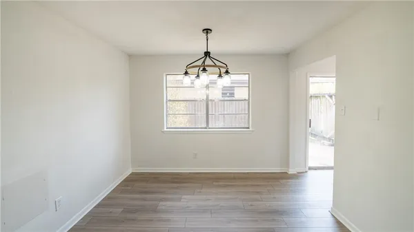 a very nice looking room with wooden floor and windows