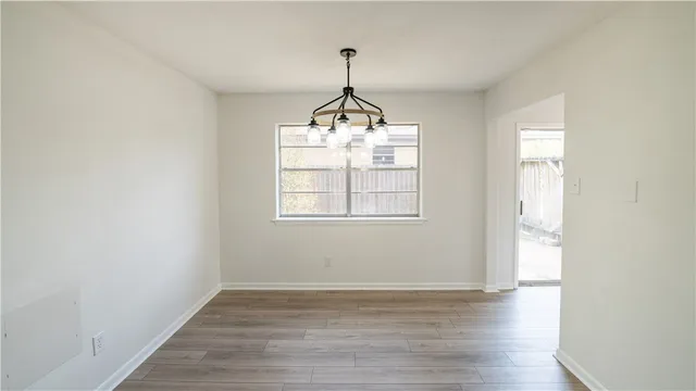 a very nice looking room with wooden floor and windows