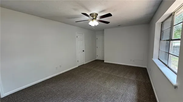 a view of a livingroom with a ceiling fan and window