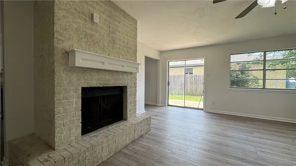 a living room with a fireplace and wooden floor