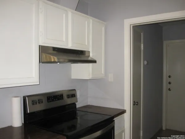 a kitchen with white cabinets and black appliances