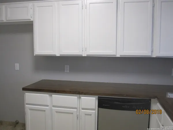 a kitchen with white cabinets and a sink