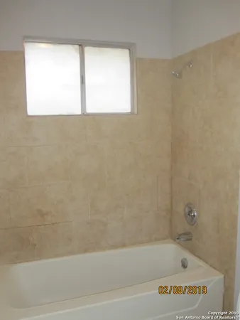 a bathroom with a bathtub and a window