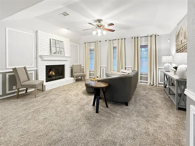a living room with furniture a fireplace and a chandelier