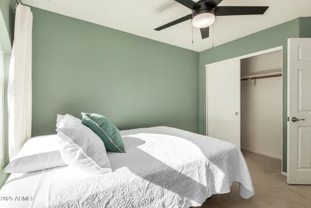 a bedroom with a bed and a ceiling fan