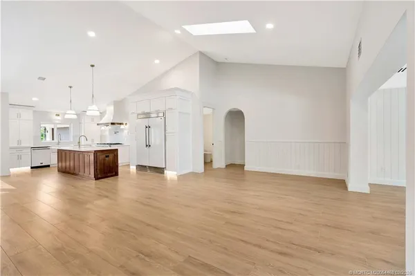 an empty room with wooden floor and window
